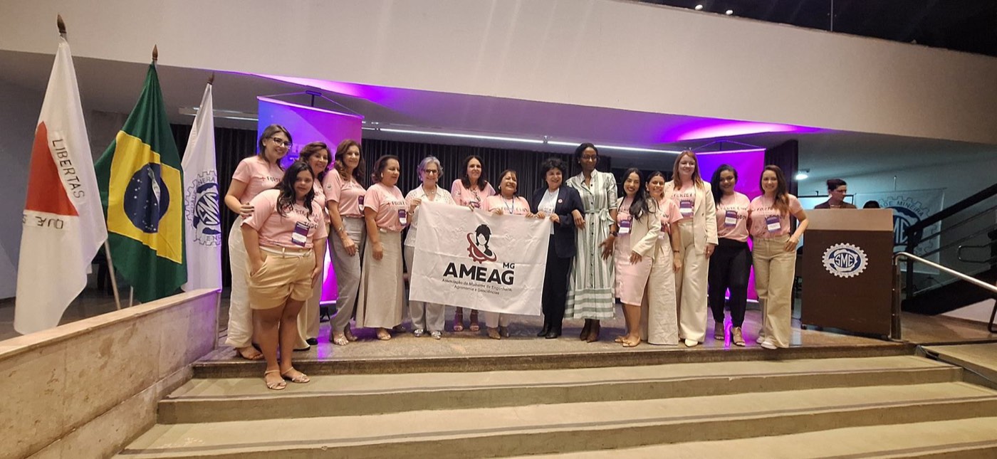 Participantes com a bandeira da AMEAG-MG no palco